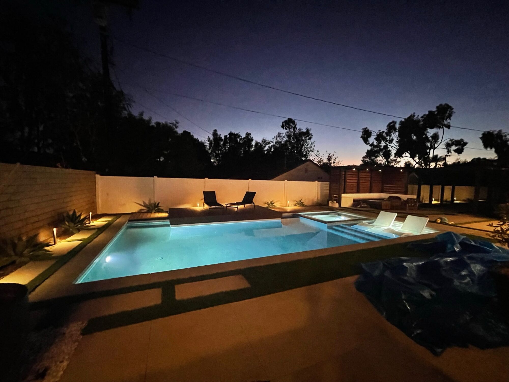 Pool and pergola lit at dusk, built by V&J