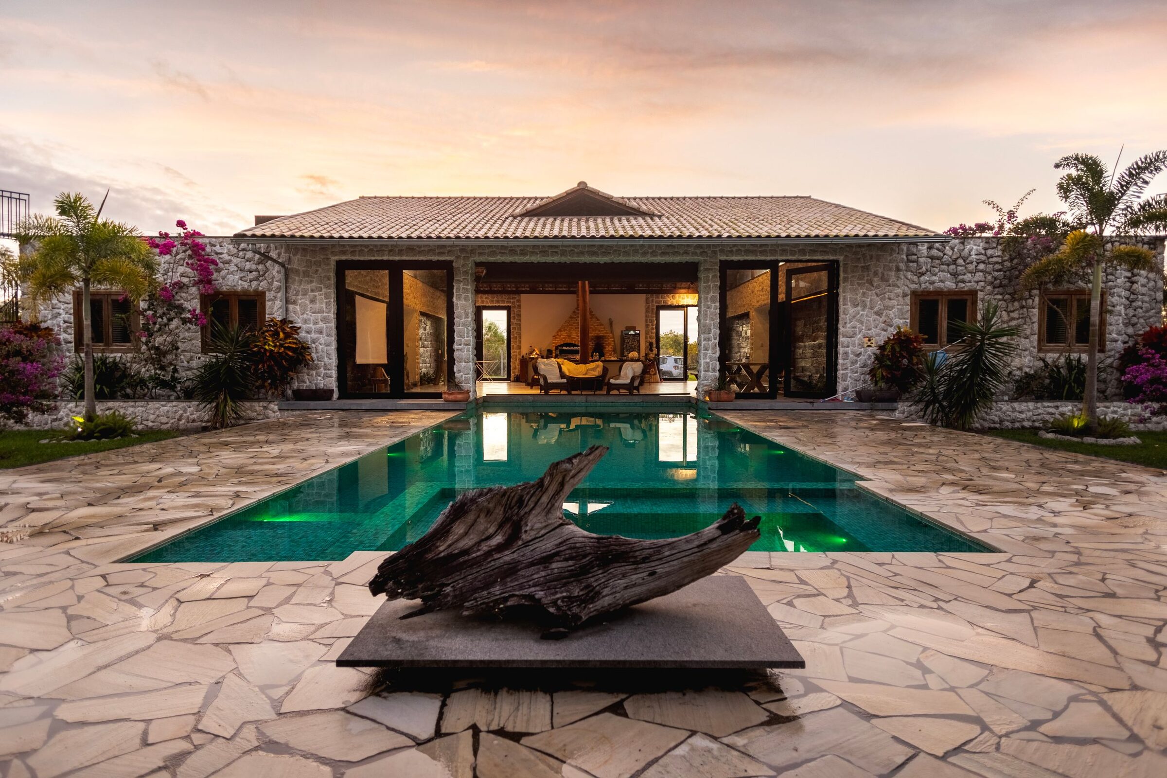 Backyard pool and villa glowing at sunset