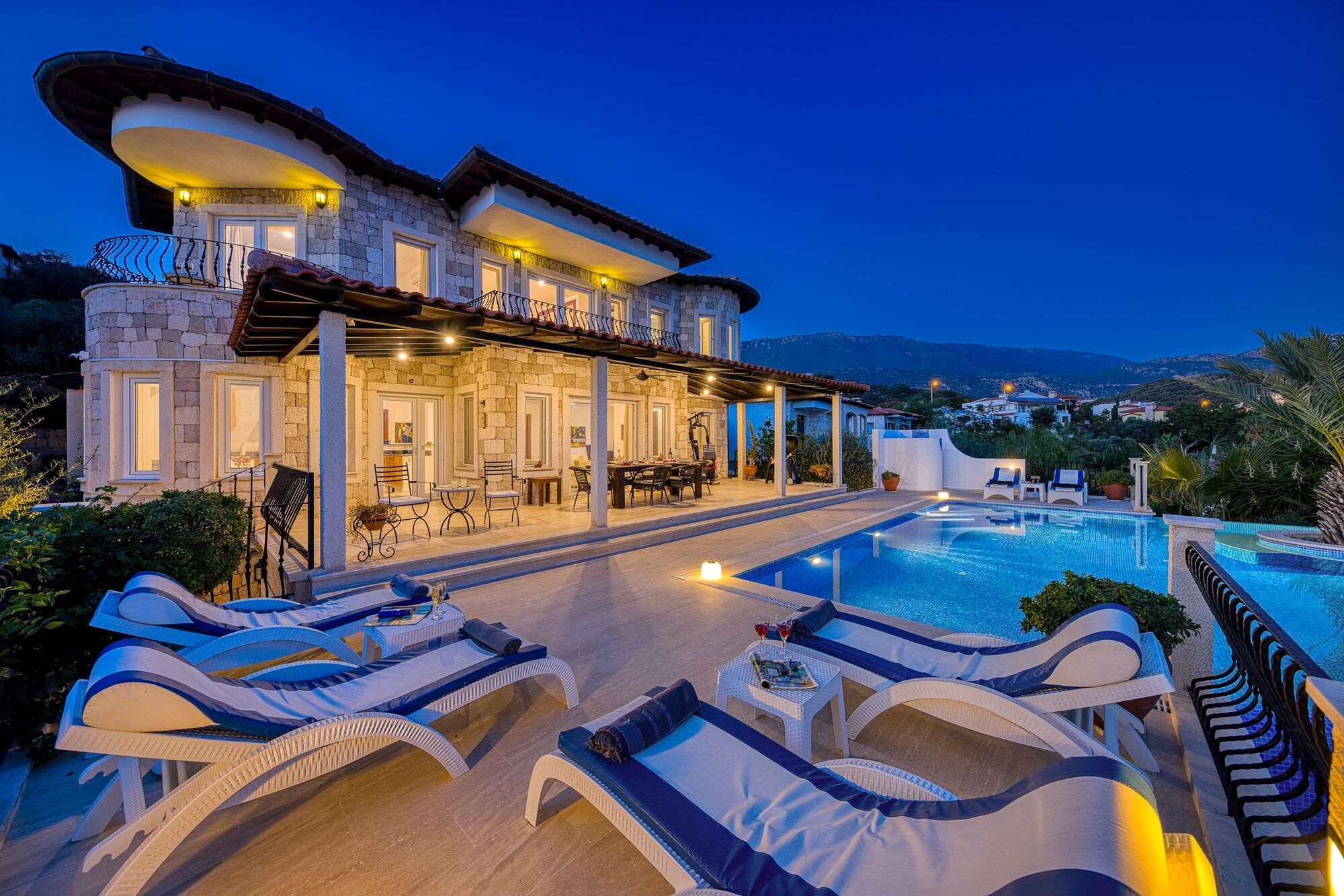 Villa terrace and pool glowing at blue-hour twilight