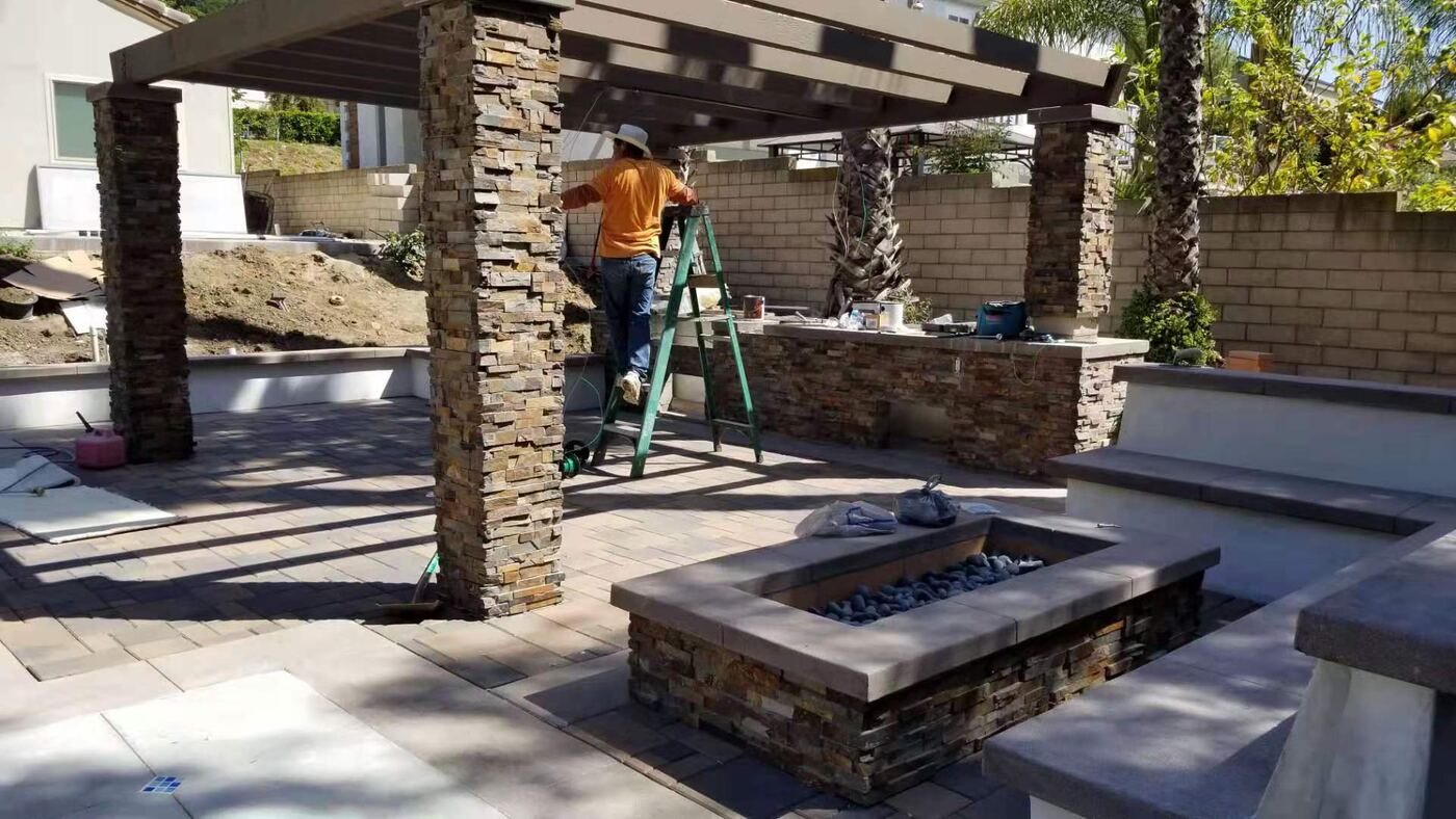 Craftsman finishing stone pergola