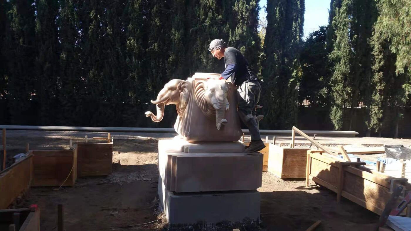 Carved stone statue being set