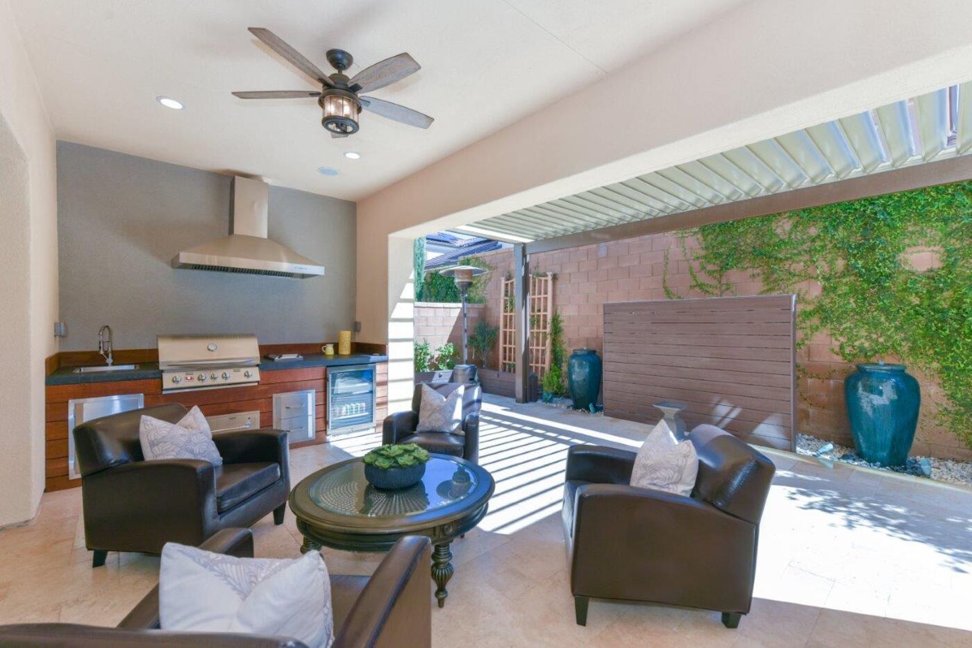 Covered patio with ceiling fans and kitchen