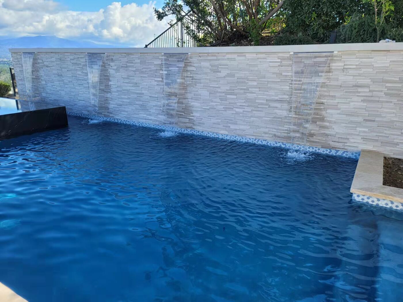 Stone waterfall falling into pool